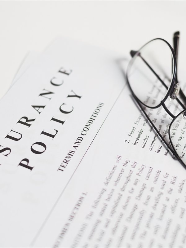 An insurance policy contract with reading glasses
