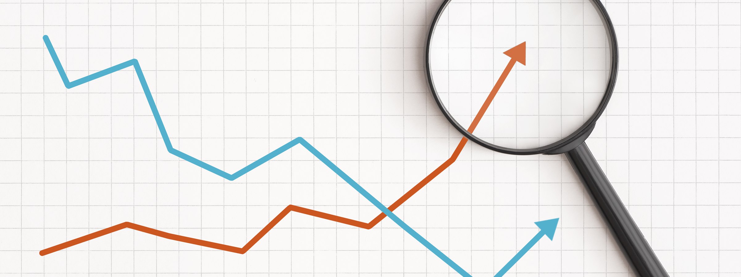 Rising trend lines and upward arrows under a magnifying glass on grid paper